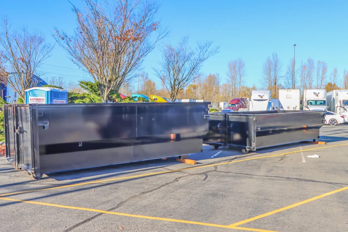 Professional dumpster rental service with roll-off container on residential driveway in Lakeland North